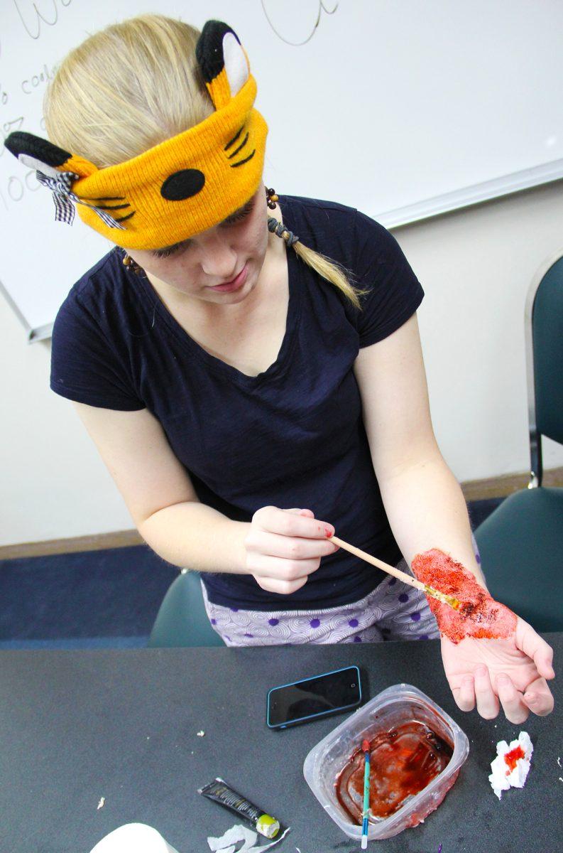 A student paints intricate marks as part of learning to cosplay.