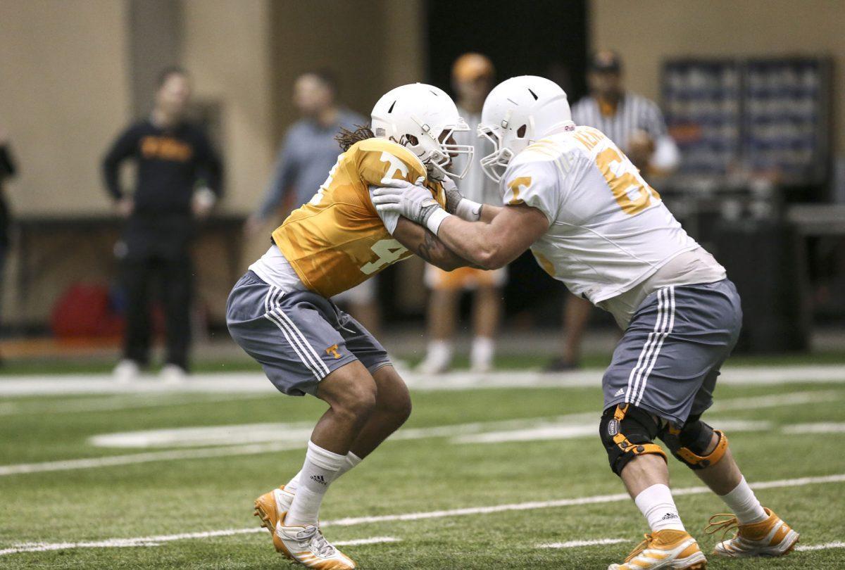 Freshman linebacker Jakob Johnson engages with redshirt freshman offensive lineman Brett Kendrick during practice Tuesday.