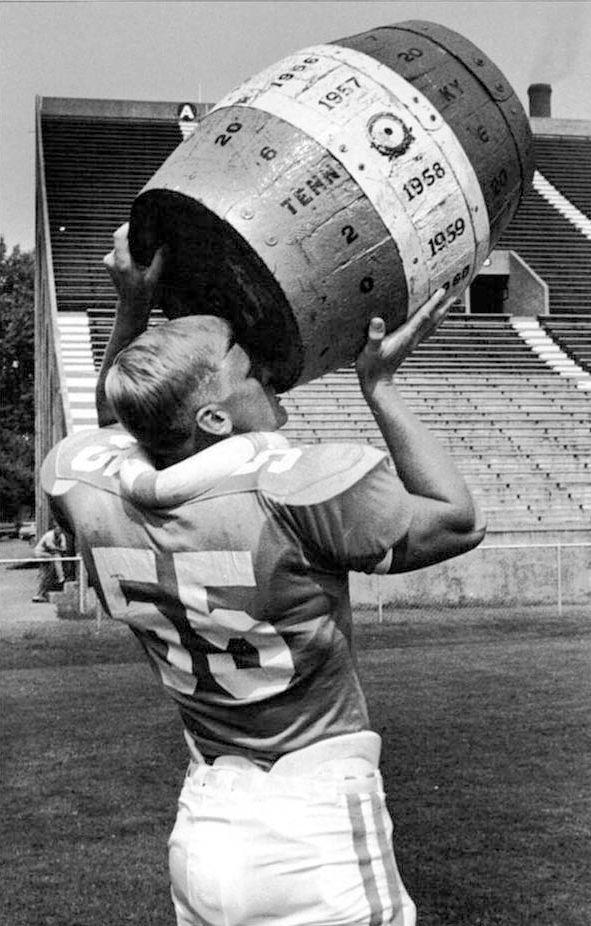 Defensive back Doug Archibald holds up the now defunct "Battle for the Barrel" trophy.