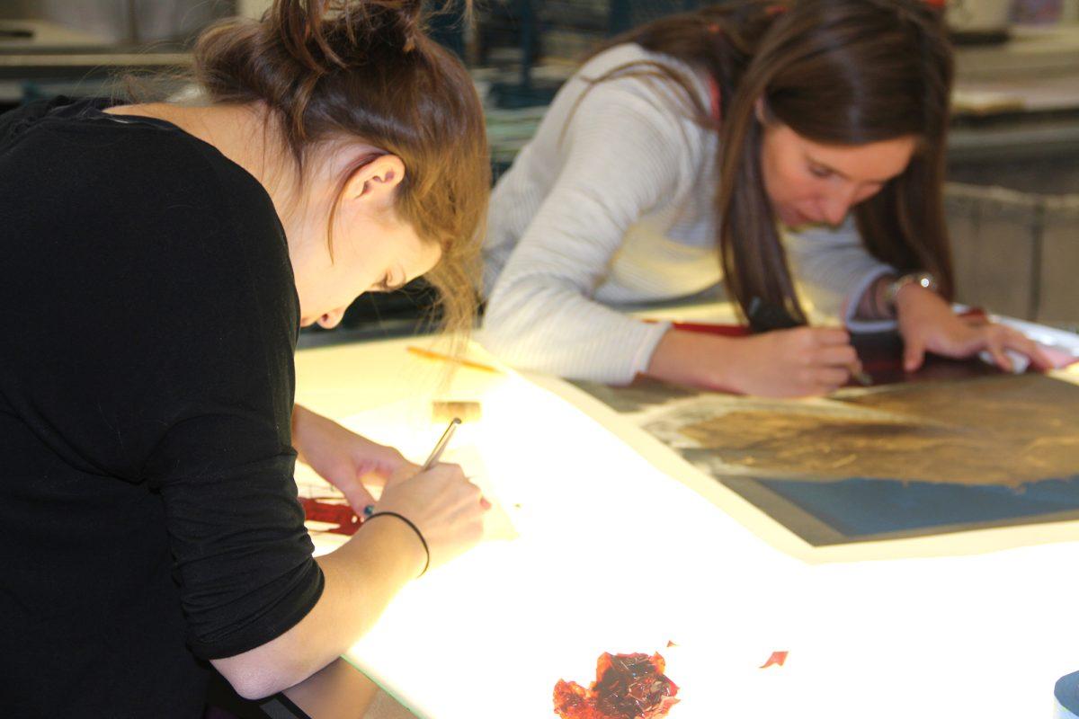 Senior Brayan Zavala, left, printmaking professor Althea Murphy-Price, center and graduate student B. Alumbaugh, right, discuss Zavala's printmaking project.
