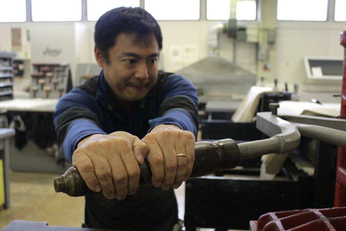 Koichi Yamamoto, associate professor of printmaking, works with a print in the studio.