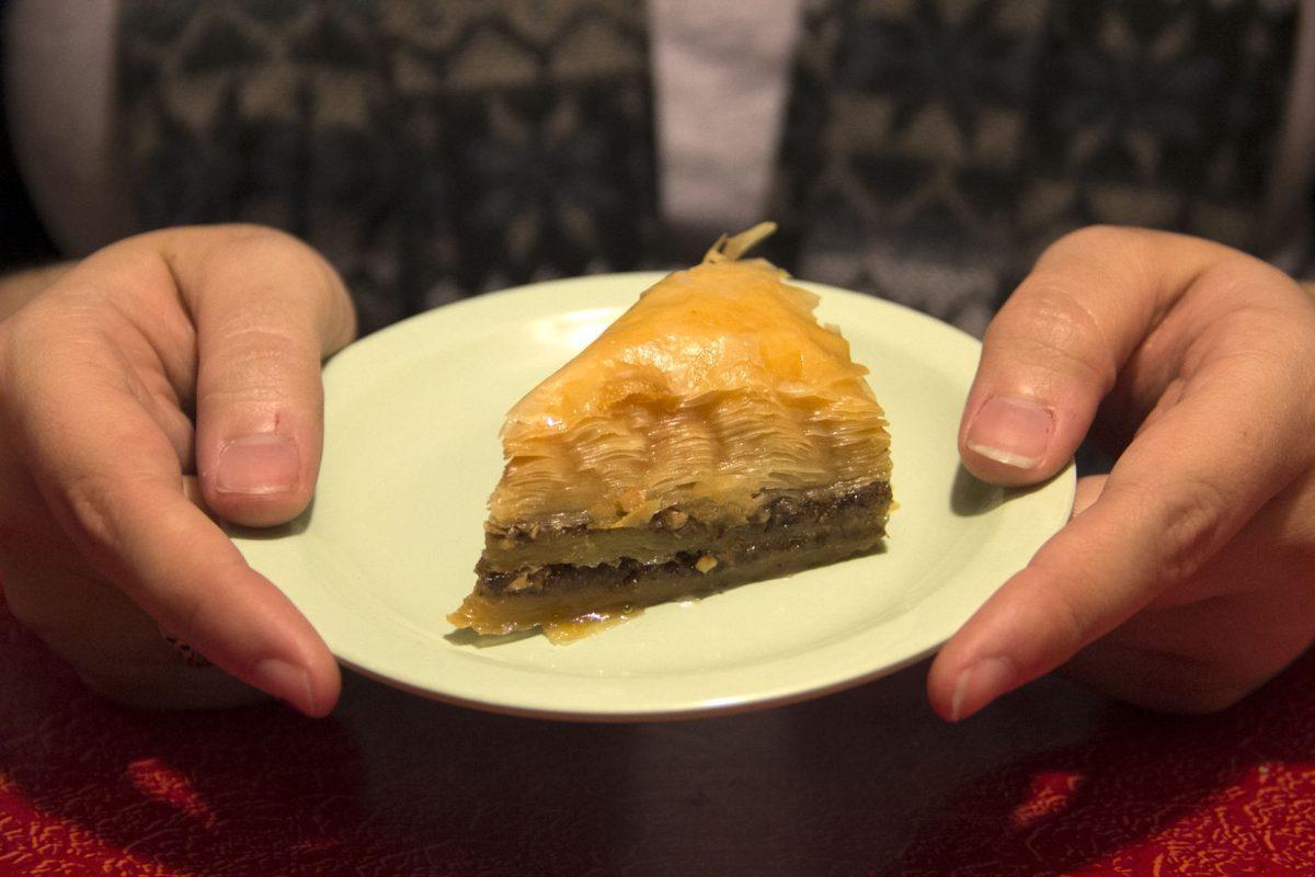 Katrina Roberts holds a section of baklava, a pastry made from thin layers of filo dough, chopped nuts and honey.