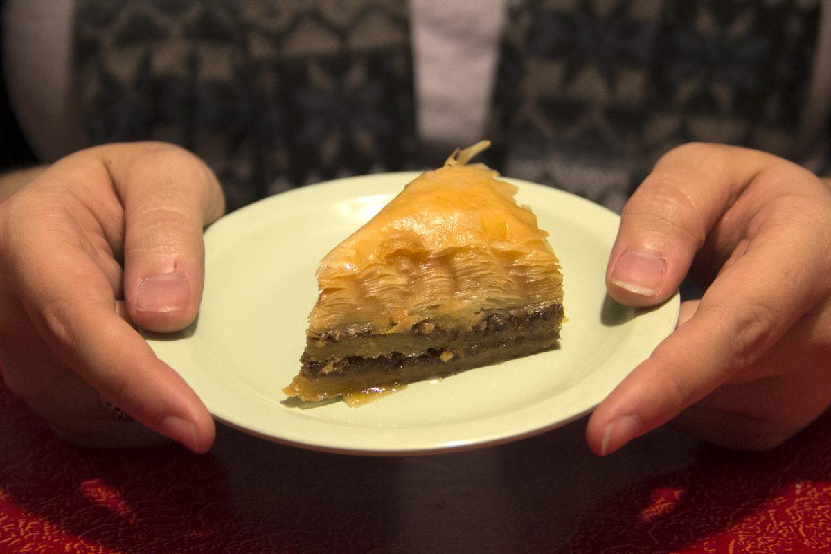 Katrina Roberts holds a section of baklava, a pastry made from thin layers of filo dough, chopped nuts and honey.