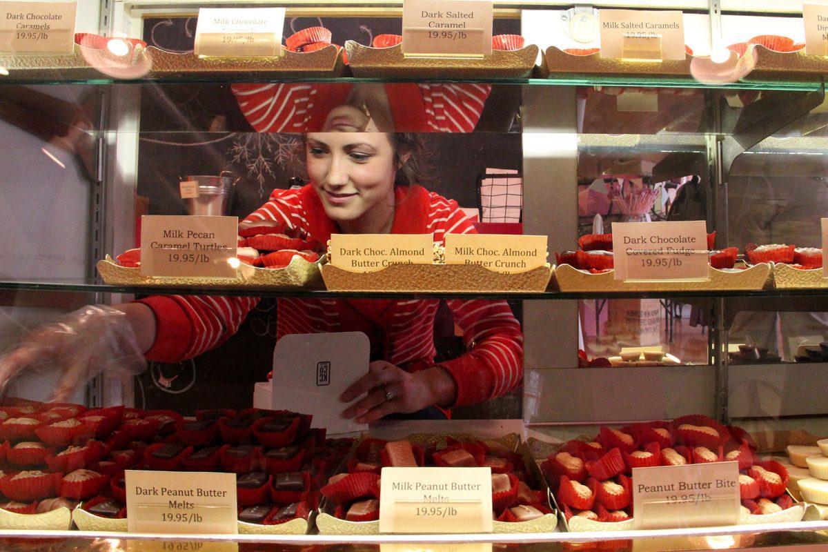 Mollie Gadlish snags some milk chocolate cheesecake bites for a customer at the Chocolate Factory.
