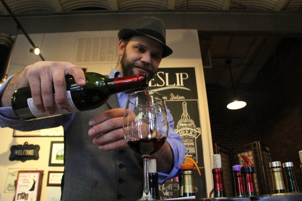 Bryce Rayburn, who has been working at Blue Slip Winery since December, pours a glass of Old City Red, a $16 wine with spicy notes and a sweet finish.