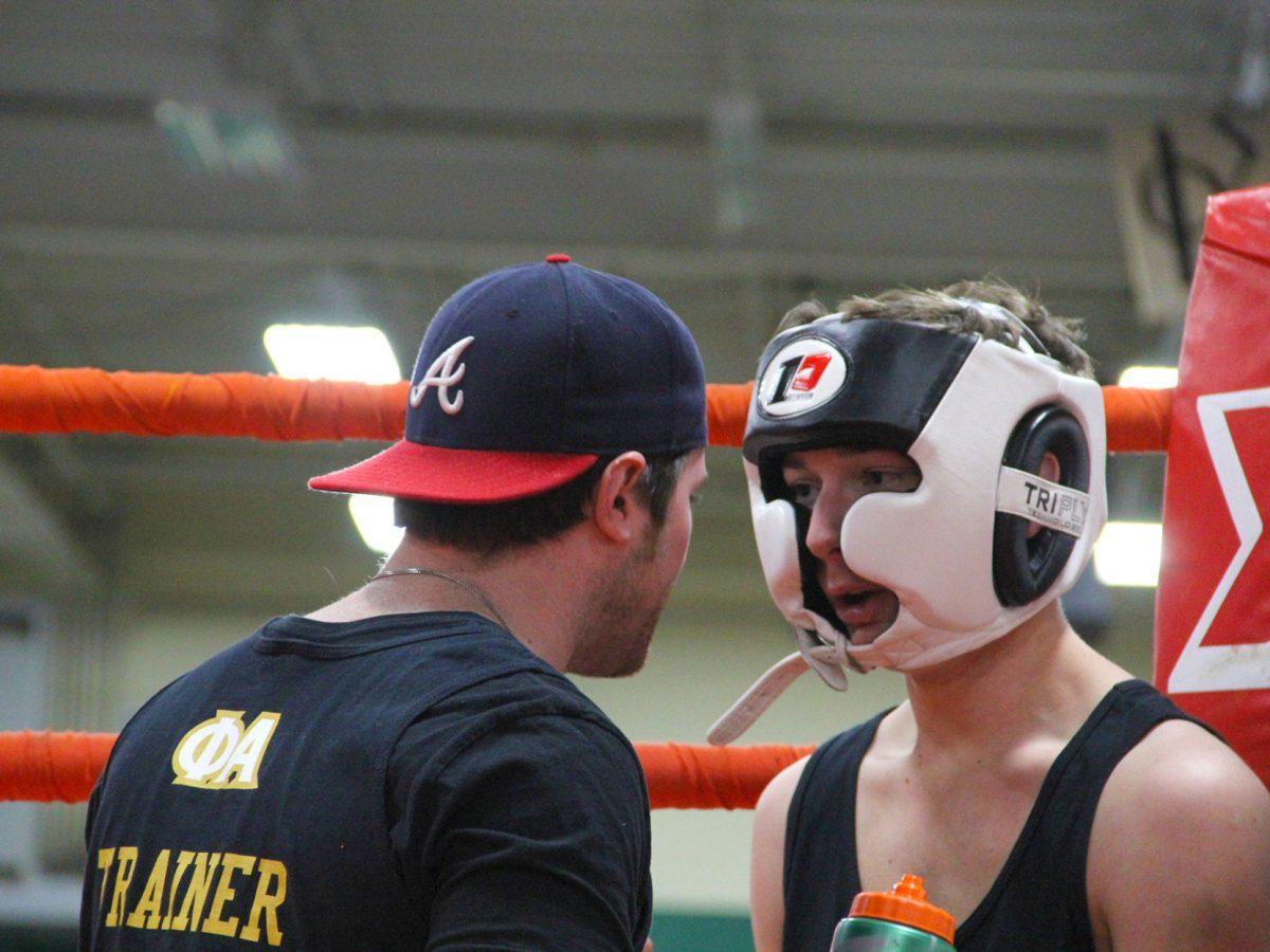 Patrick Costa (right) of Sigma Alpha Epsilon gets a pep talk from a trainer during a break between rounds.
