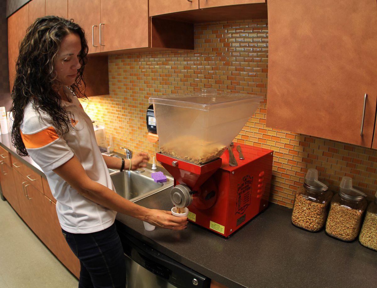 Allison Maurer, sports nutritionist, makes fresh-pressed peanut butter in the Anderson Training Center.