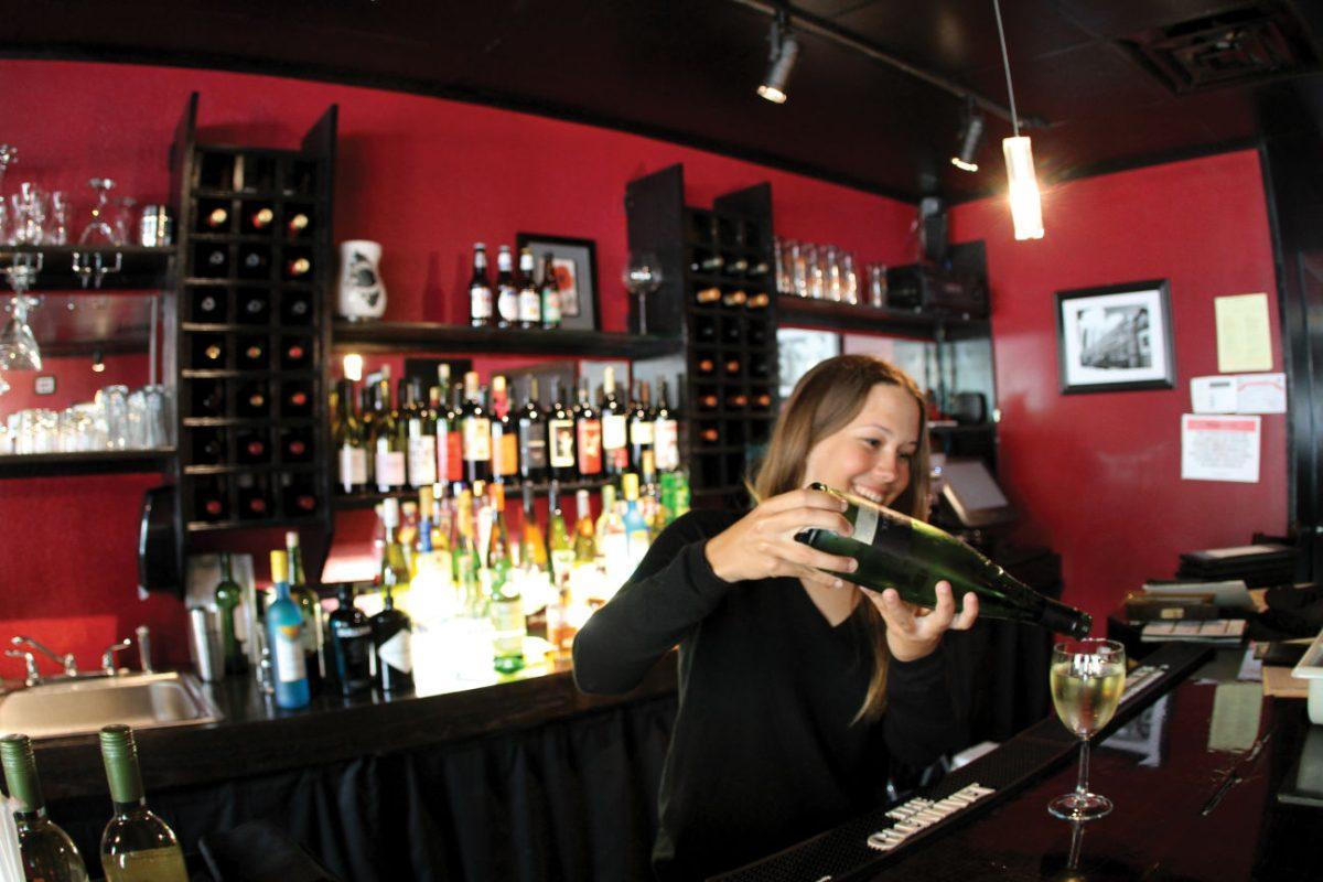 A Cafe du Soleil employee pours wine in the cozy French restaurant in downtown Knoxville.