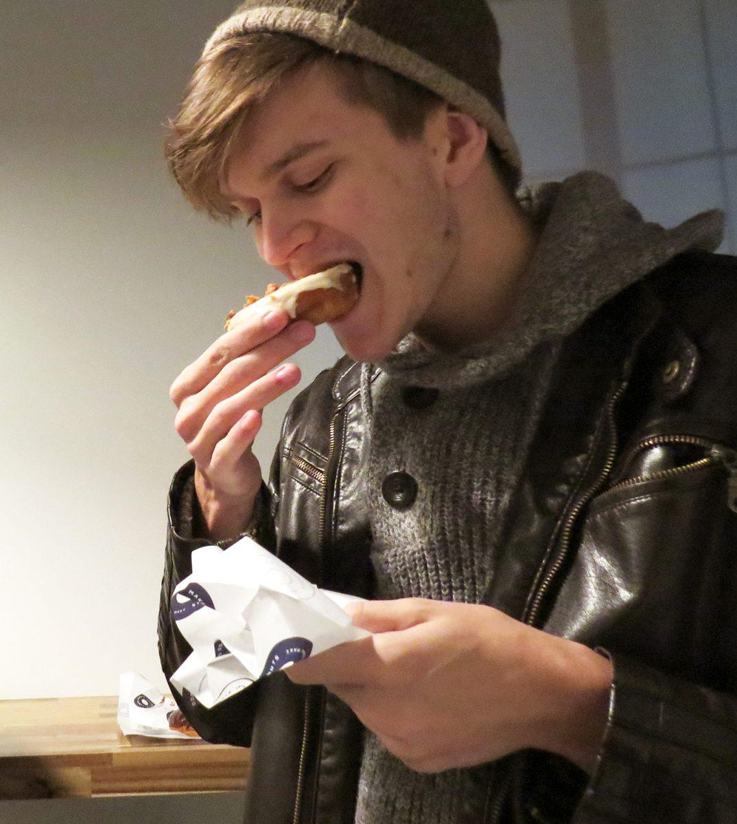 Junior Tyler Kibbey enjoys a free maple bacon flavored donut.