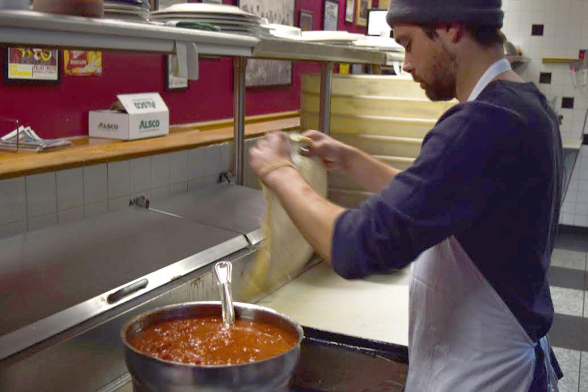 James Andrews, an employee of Dazzo's Pizzeria, begins to make a pizza.