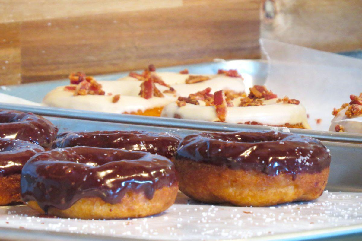 Two of the unique varieties offered by Makers Donuts: Chocolate Ganache with Sea Salt and Maple Bacon.