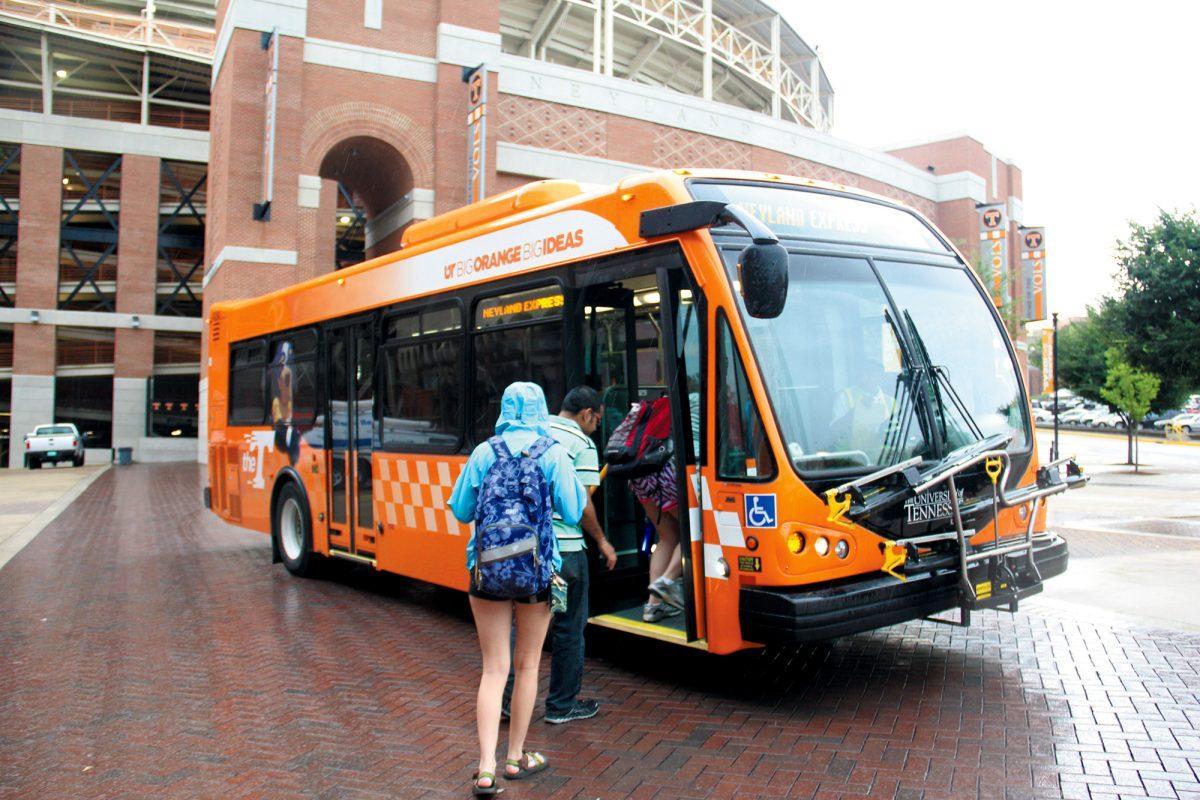 Students escape the rain on a T-Link bus in front of the Alumni Memorial Building.