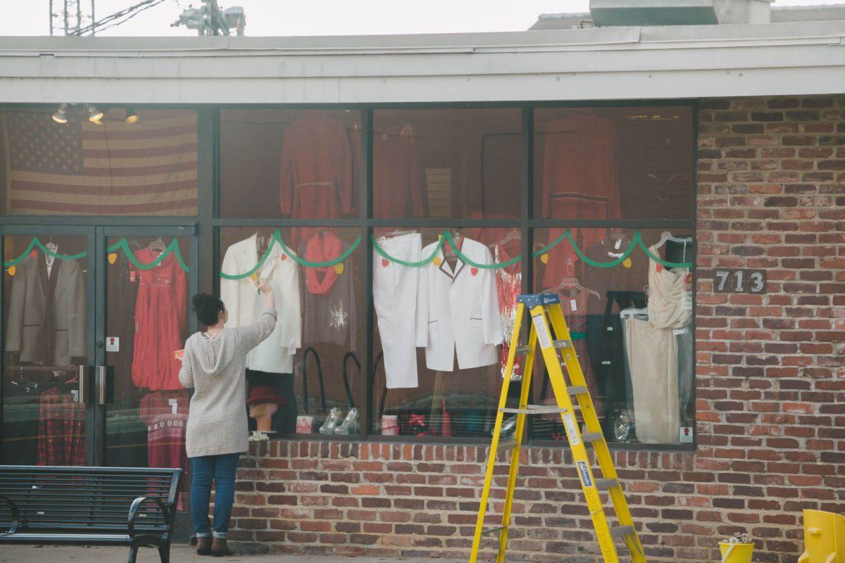 Students begin to paint the Goodwill located on 17th Street with a holiday theme on Dec. 1, 2017. 