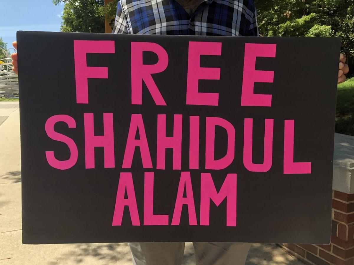 A student holds a sign at a Bangladeshi Students Association protest. 