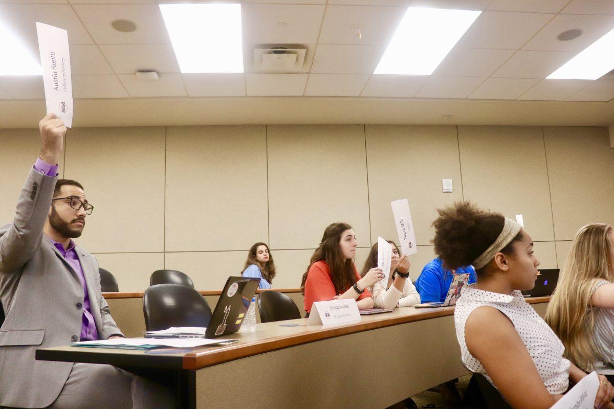 Austin Smith casts his vote for the College of Nursing towards banning plastic straws at the Student Government Association Senate meeting on Sept. 11, 2018. 