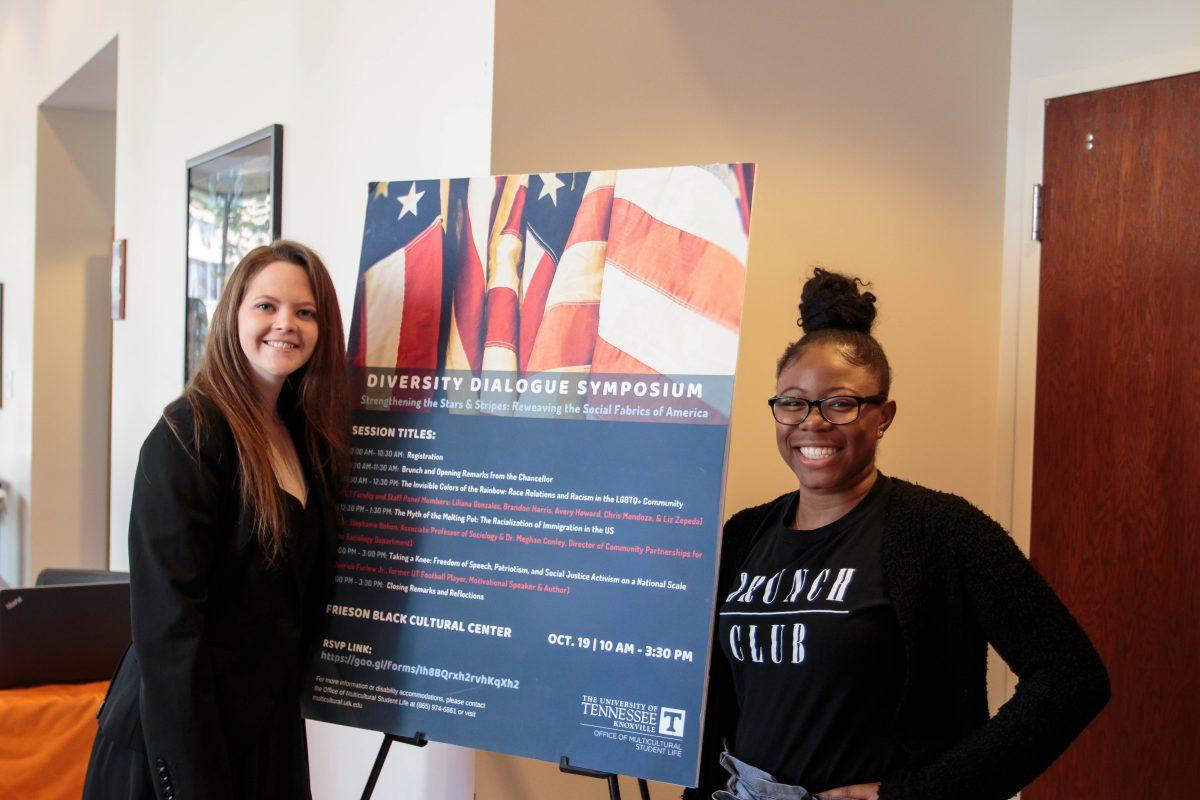 Students pose with the overview schedule of the Diversity Dialogue Symposium held in the Frieson Black Cultural Center on Oct. 19, 2018. 