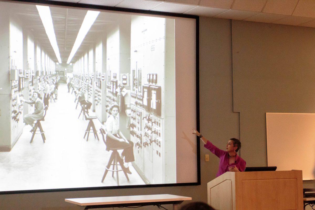 Denise Kerinan discusses a photo of the women who worked on uranium machines during her lecture on Nov. 7, 2018. 