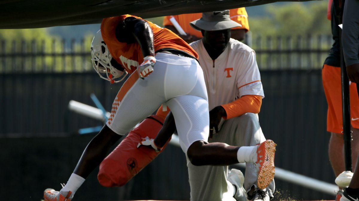 Co-defensive coordinator Chris Rumph running drills with a player during Tennessee football practice. 