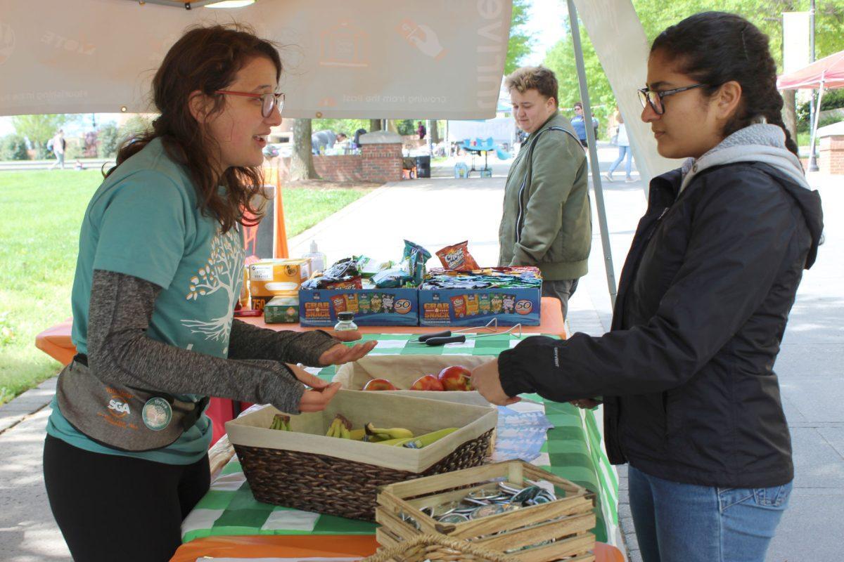 Caitlin Lloyd, a Thrive campaign member, speaks to a student at Thrive's booth on Ped Walkway on Monday April 15, 2019.