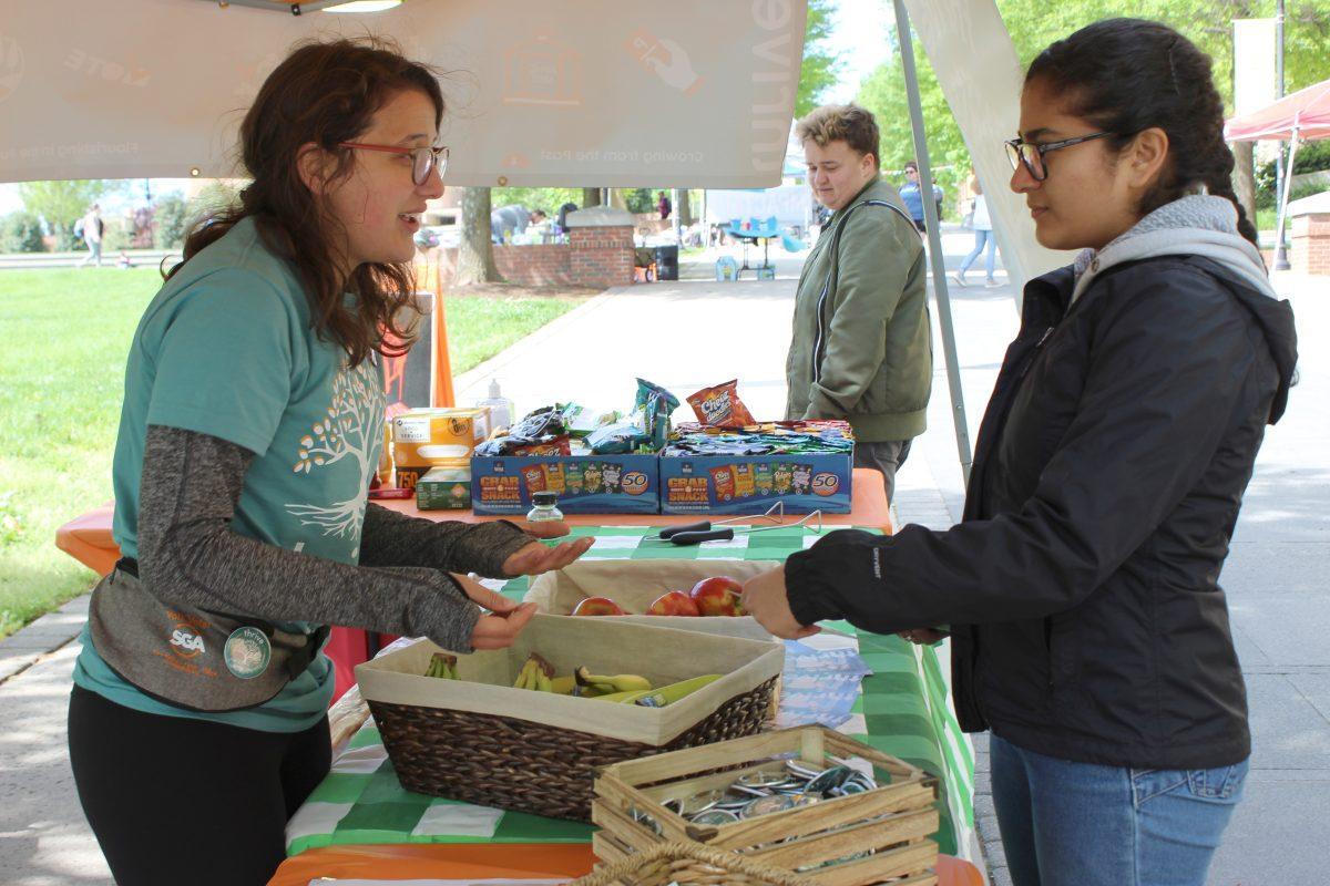 Caitlin Lloyd, a Thrive campaign member, speaks to a student at Thrive's booth on Ped Walkway on Monday April 15, 2019.