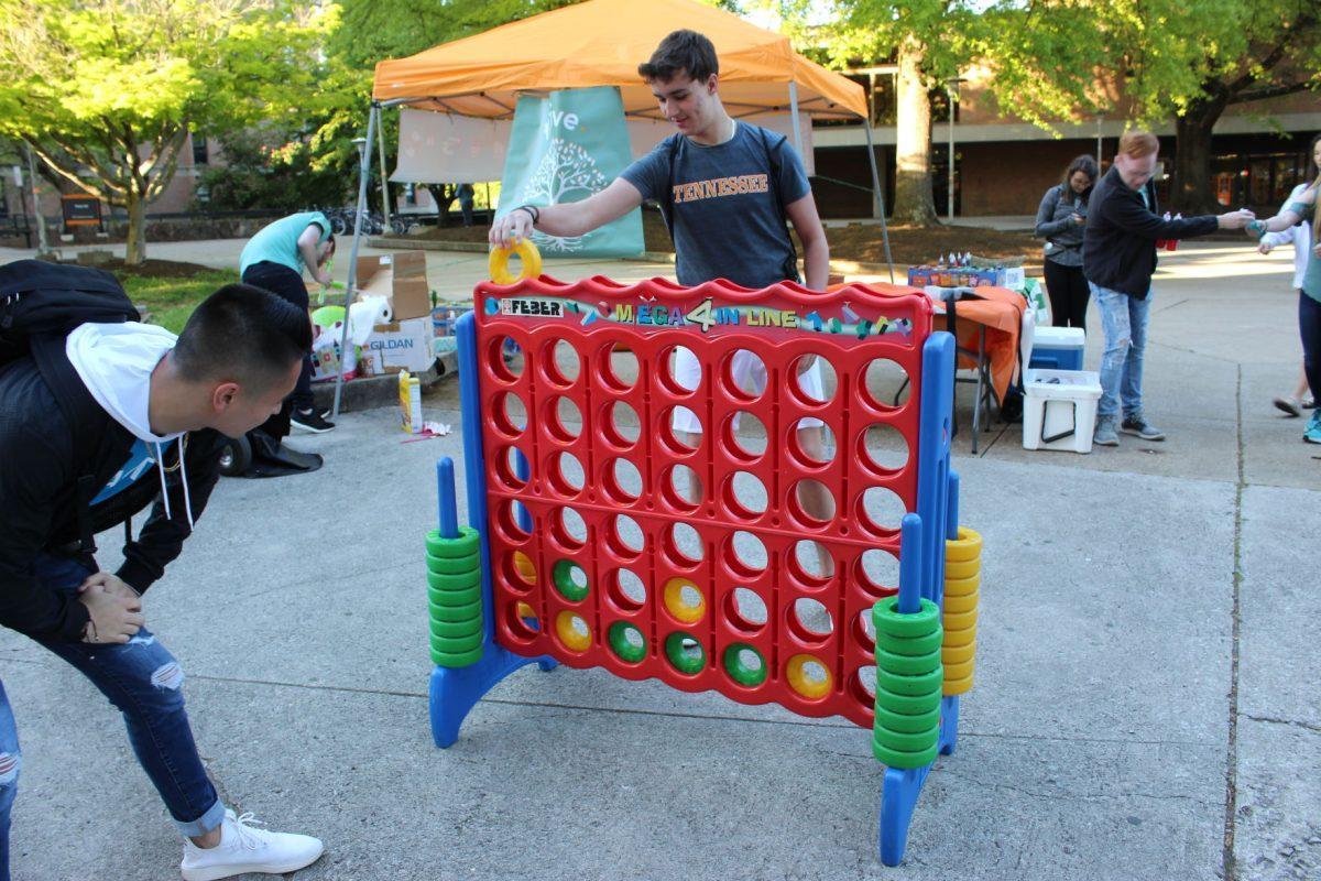 Communication senator candidate for Thrive, Joe Staton (left) plays "Connect 4" with another student at McClung Plaza on Monday April 15, 2019.