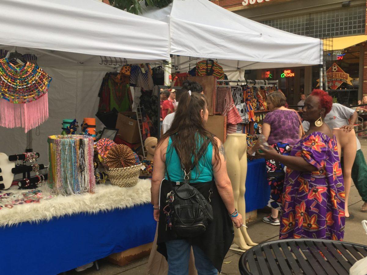 A woman comes to take a look at vendor Veronica Shayaam's clothing and jewelry for sale. Shayaam, originally from Grenada, comes to Kuumba Festival every year.  