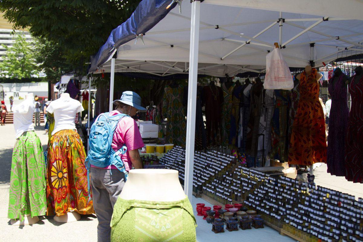 A customer browses Hajie Njaie's wares, which include two types of African Black soap, a large assortment of skin oils, pure shea butter and clothing.