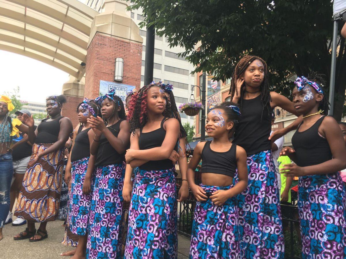 Some of the youngest members of the Watoto troupe wait their turn to dance. 