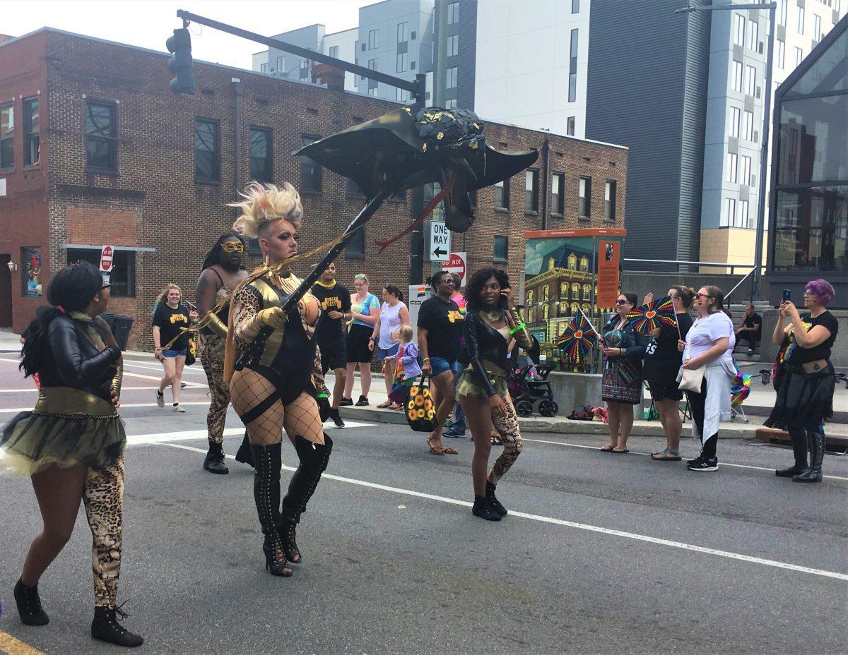  Wearing dark clothing and carrying a cobra puppet, group members of Nubian Sass march down Gay Street. 