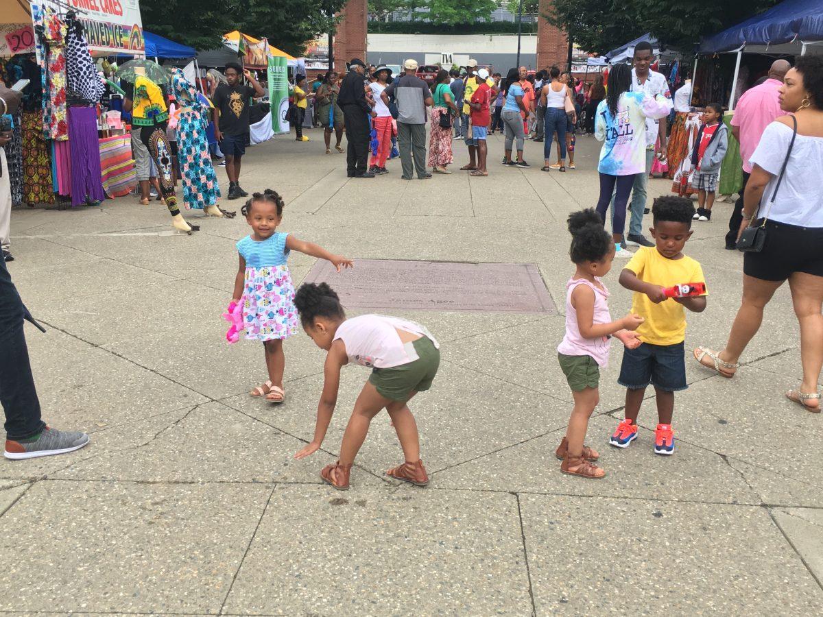 Children play with a bubble gun in the middle of Market Square at Kuumba Festival.