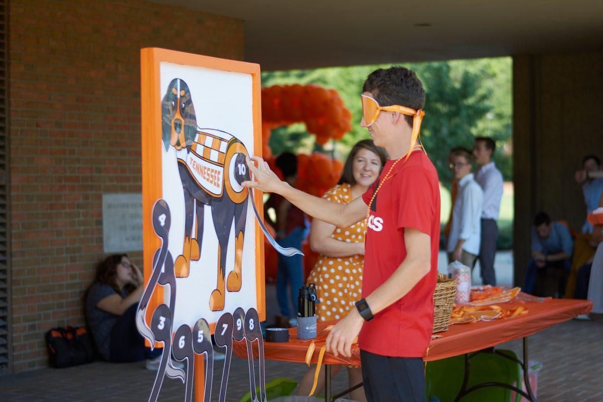 Gabe Peck, freshman in wildlife and fisheries, attempts to pin the tail on Smokey at the Big Orange Birthday Party at the HSS Plaza. 
