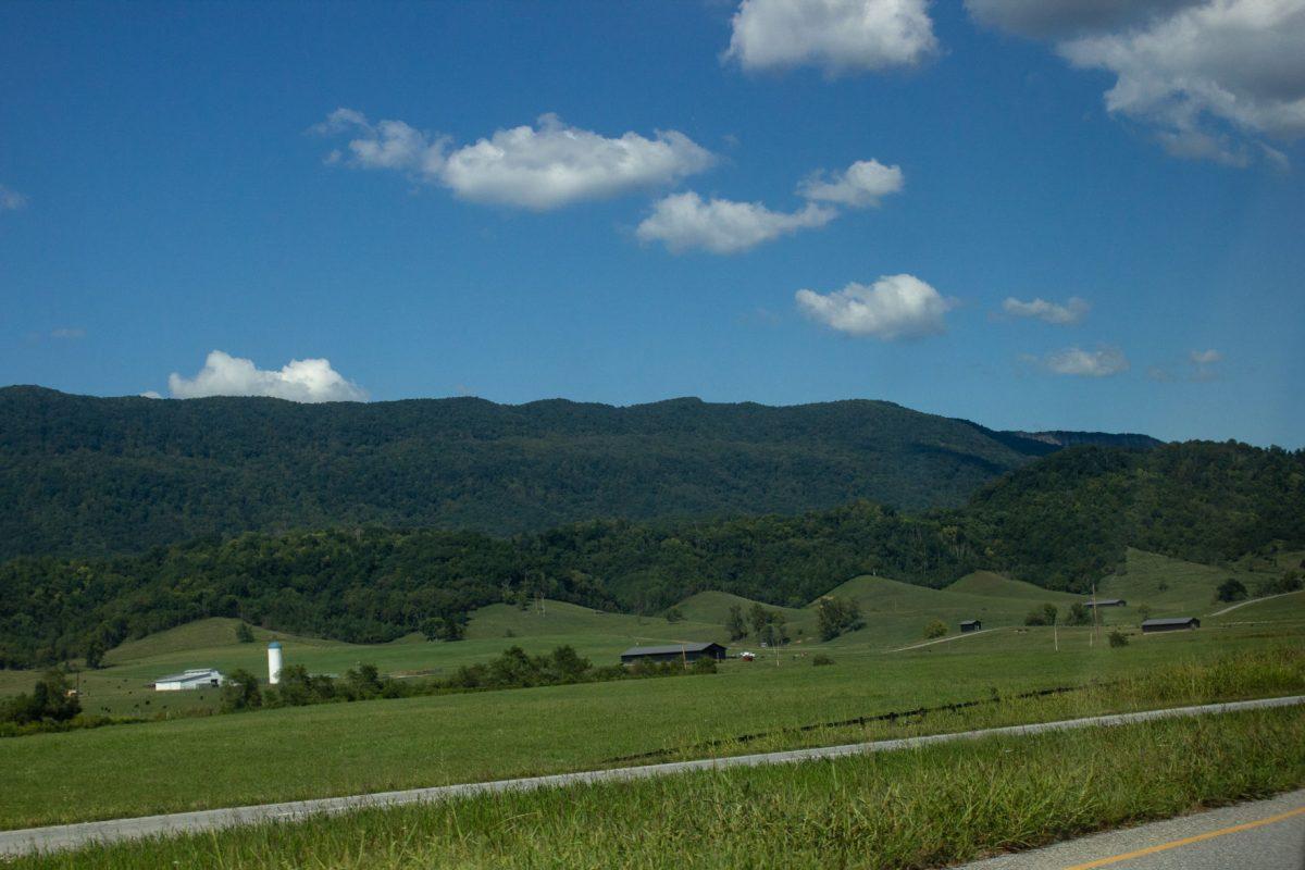 Barns dot the foreground along Tennessee Route 63, set against the wave-like foothills of the Cumberland Mountains.