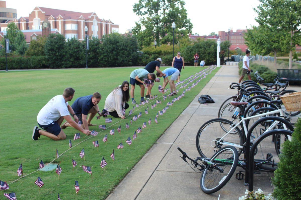UT students of the Young Americans for Freedom foundation chapter work as the sun sets on September 10, 2019 to place 2,977 flags to represent all the lives lost during the 9/11 terrorist attacks.