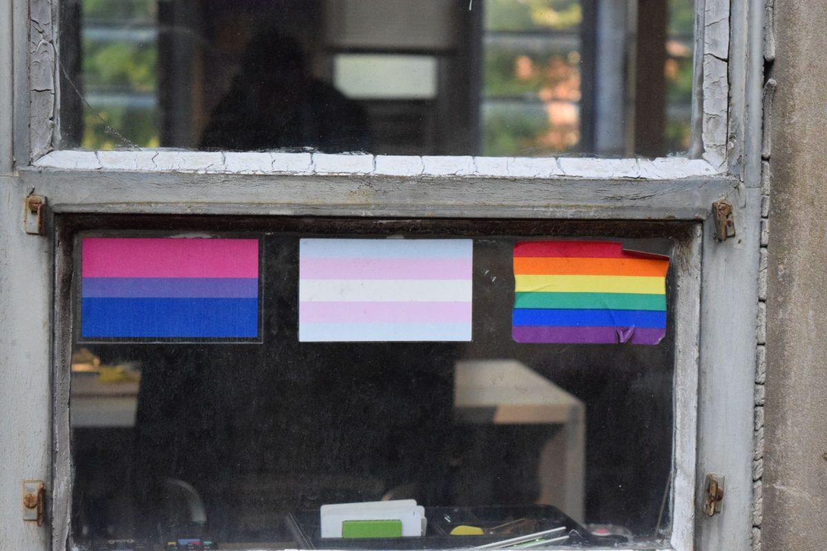 A sticker of the Bisexual pride flag, the Transgender flag and the Pride flag decorate an outside window of the Pride Center at Melrose Hall F at 915 Volunteer Blvd.