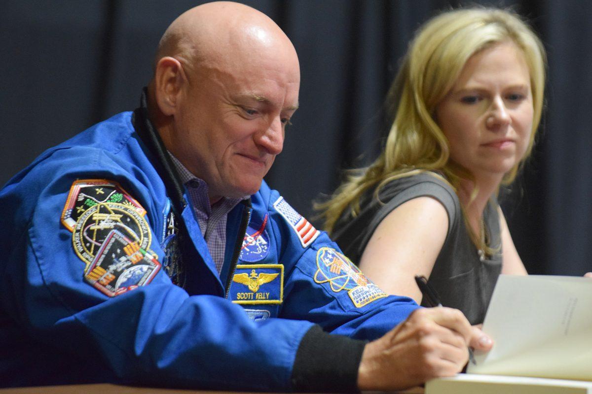 Scott Kelly signs a copy of Leaving Orbit: Notes from the Last Days of American Spaceflight, written by Margaret Lazarus Dean.