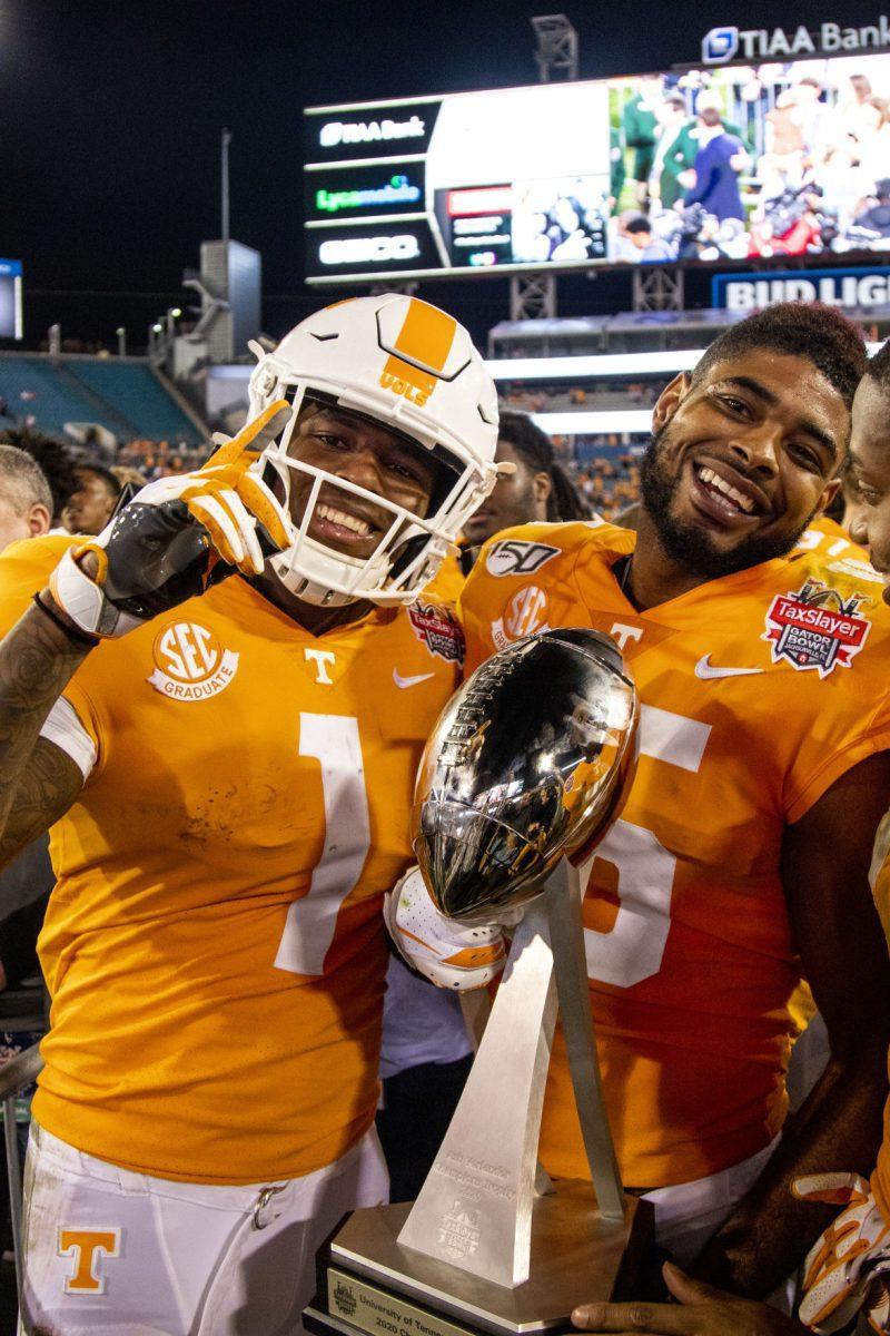 #1 Marquez Callaway and #15 Jauan Jennings showing off the trophy after the victory at the 2020 Tax Slayer Bowl game.