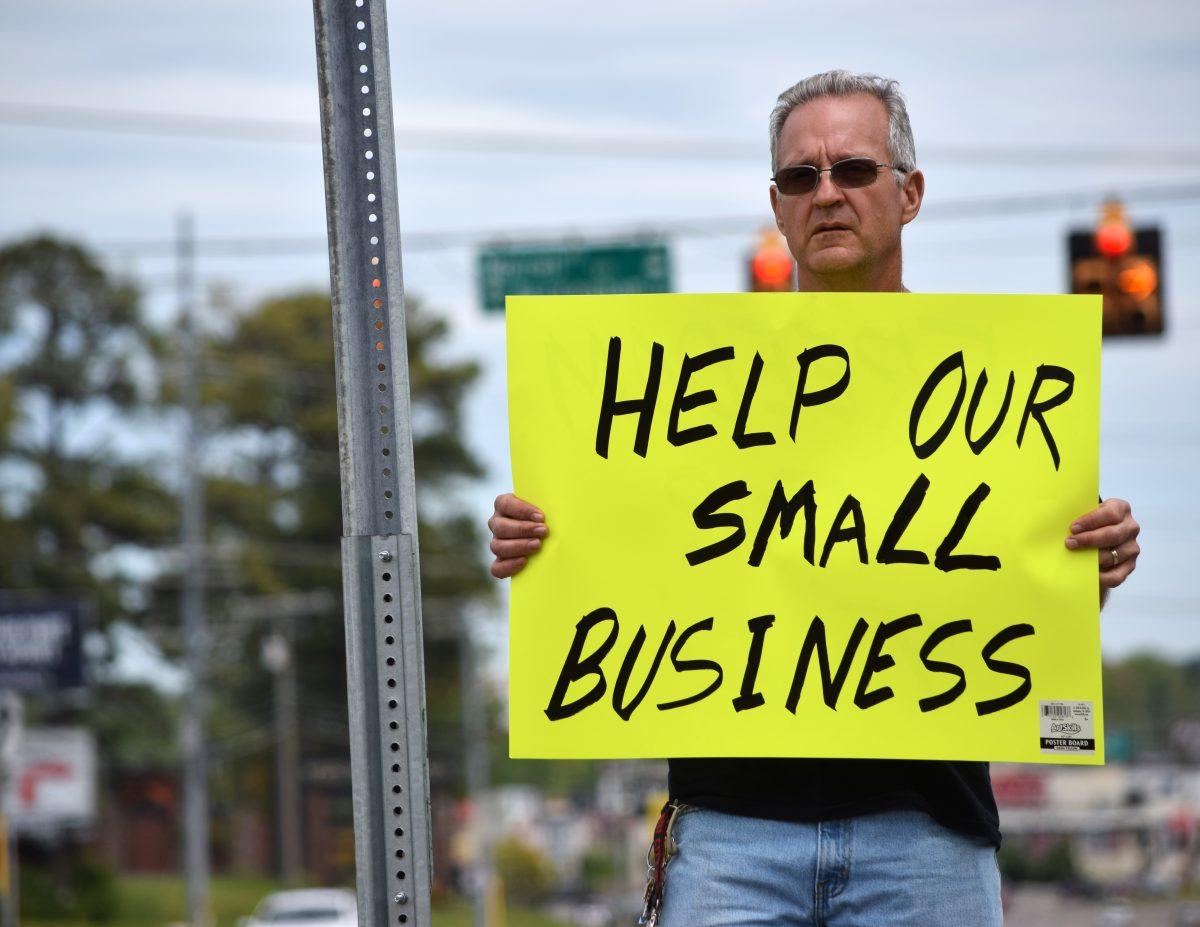 A protester holds up a sign at the Knoxville Freedom Rally protest in front of West Town Mall along Kingston Pike on Sunday, April 19, 2020. The rally is in reaction to Governor Bill Lee's shutdown of nonessential businesses because of the coronavirus pandemic.