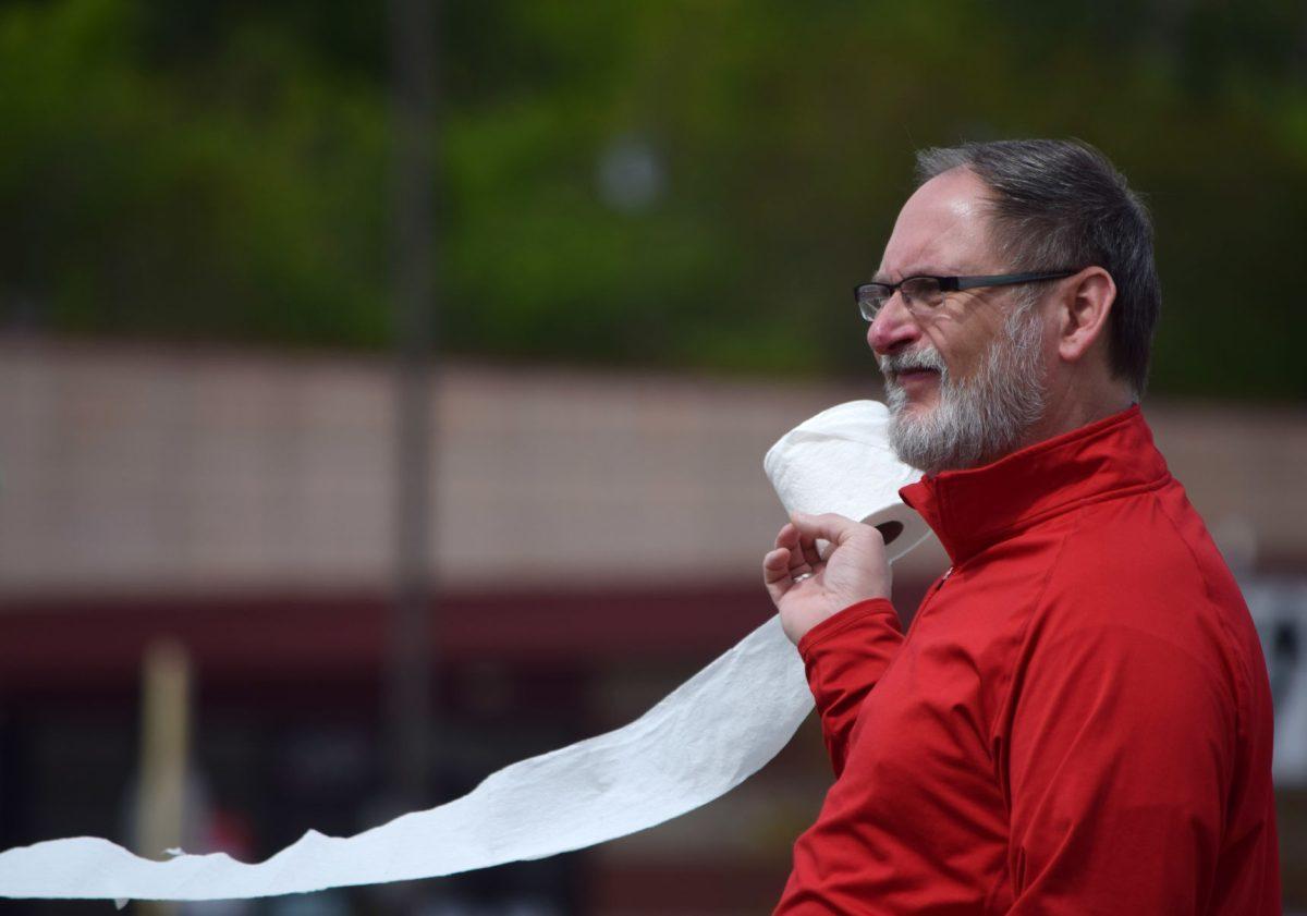 A protester holds a roll of toilet paper during the Freedom Rally outside of the closed West Town Mall along Kingston Pike on Sunday, April 19, 2020. 