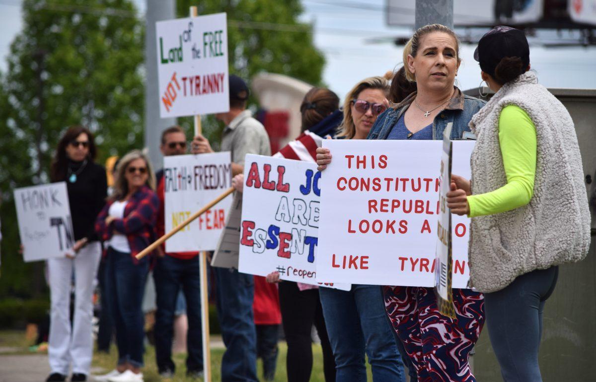 Protesters wave and hold signs along side Kingston Pike outside of the closed West Town Mall during the Freedom Rally held on Sunday, April 19, 2020. The protest, one of seven across Tennessee, was to protest Governor Bill Lee’s stay-at-home orders and the closure of many local businesses with his mandatory shutdown of nonessential businesses.