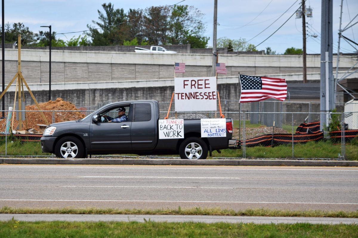 A truck drives on Kingston Pike across from the Freedom Rally protesters as they lined the sidewalks outside the closed West Town Mall on Sunday, April 19, 2020. The truck sported signs inline with the protest against coronavirus-related shutdowns in Knoxville.