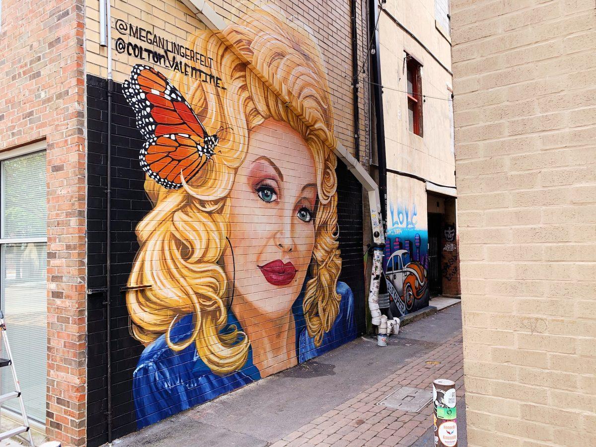 Artist Megan Lingerfelt restored this mural of Dolly Parton, originally by Colton Valentine, in Strong Alley after the mural was defaced in April.