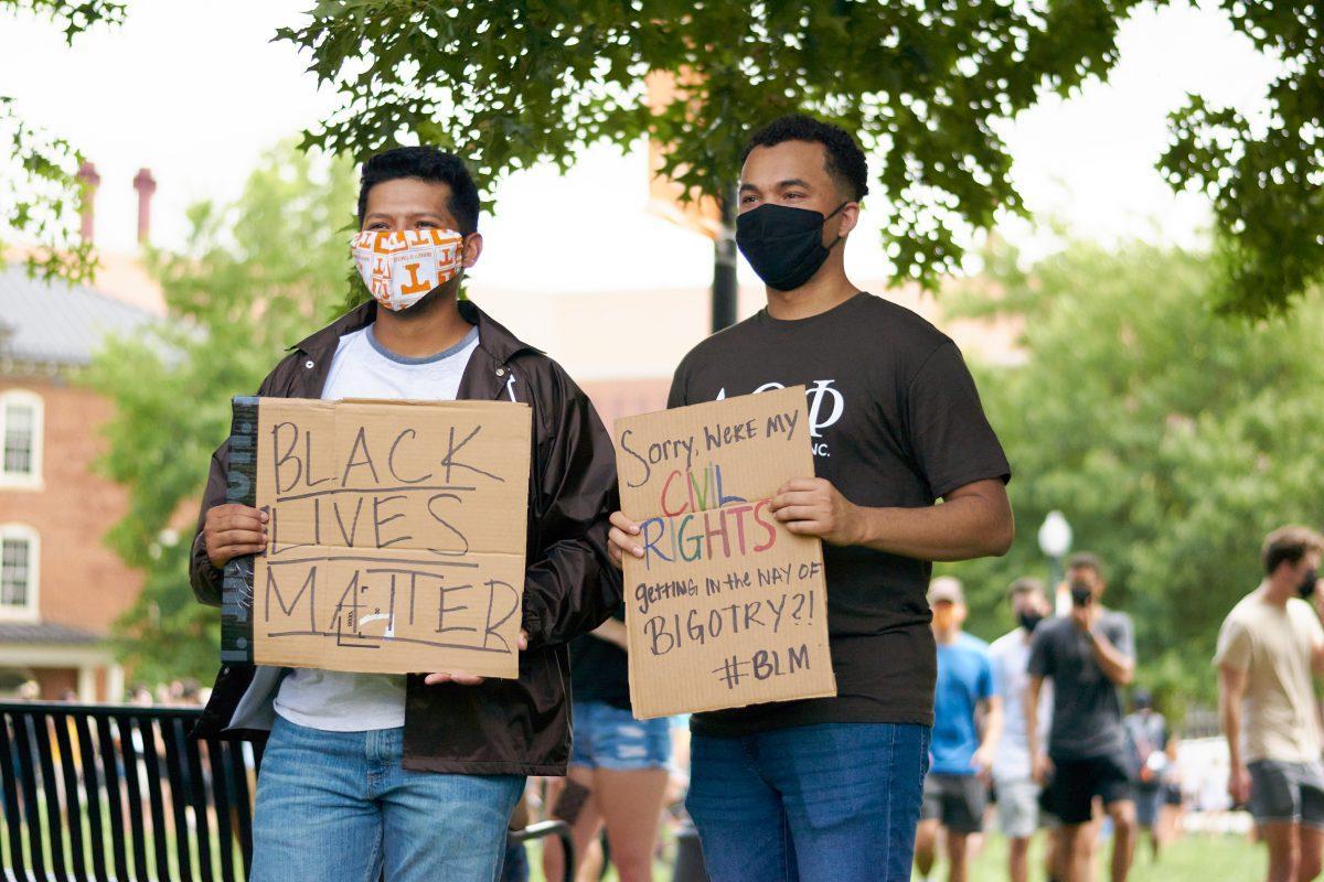 A pair of supporters pose with signs at Ayres Hall, at the end of the BLM March on August 29, 2020.
