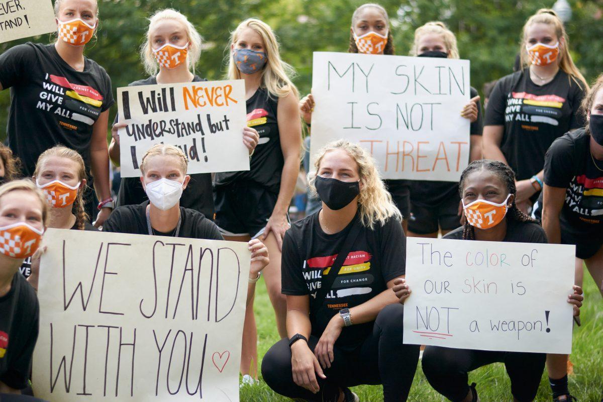 A group of supporters pose with signs at Ayres Hall, at the end of the BLM March on August 29, 2020.