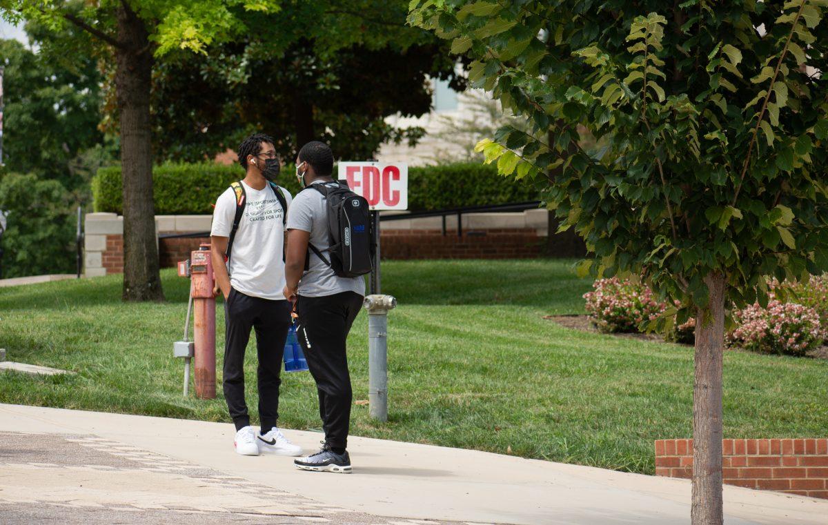 Two UT students conversing between classes while wearing masks on Thursday, August 20, 2020.