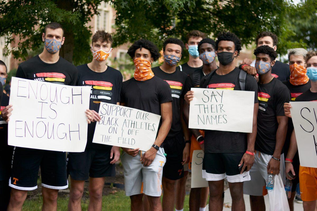 A group of supporters pose with signs at Ayres Hall, at the end of the BLM March on August 29, 2020.