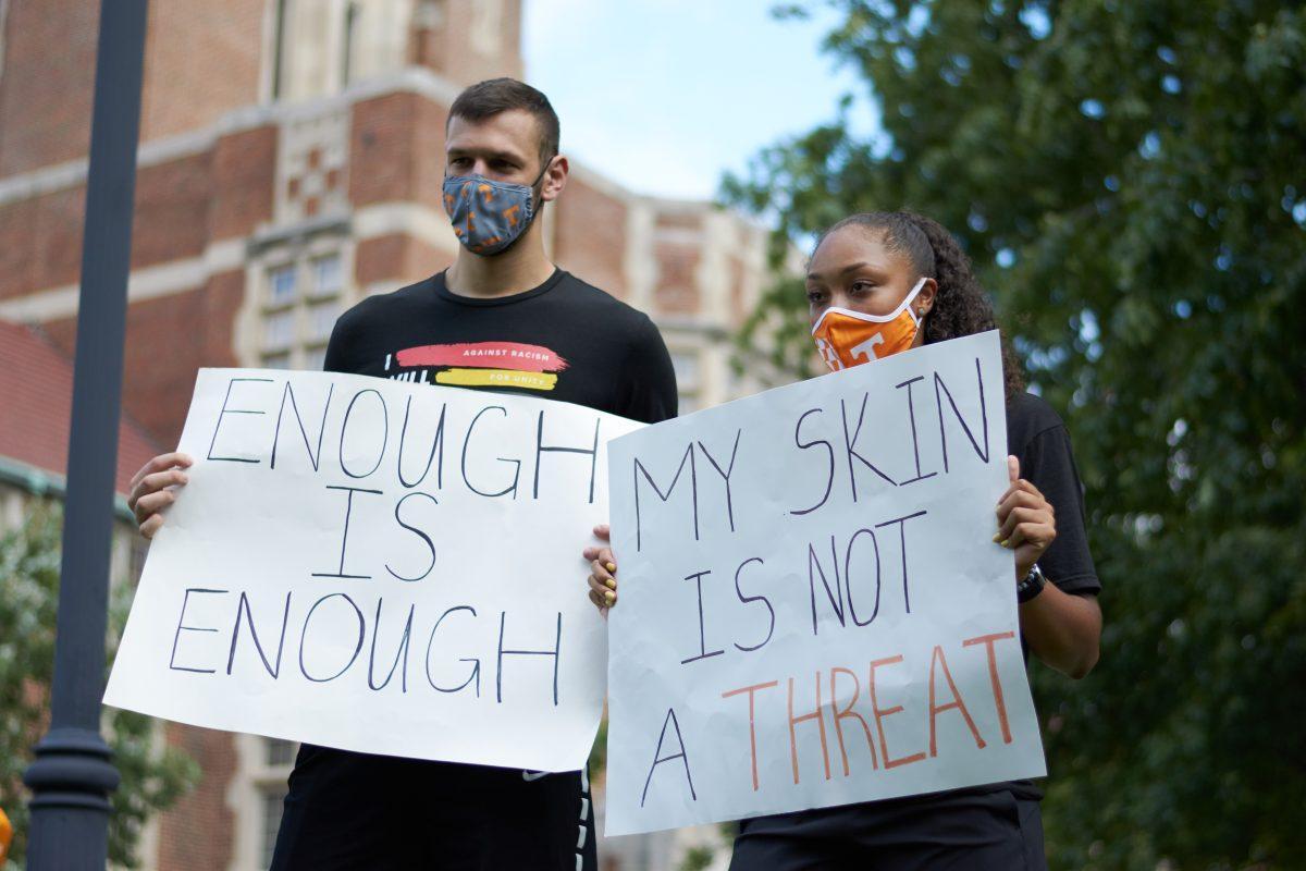 A pair of supporters pose with signs at Ayres Hall, at the end of the BLM March on August 29, 2020.