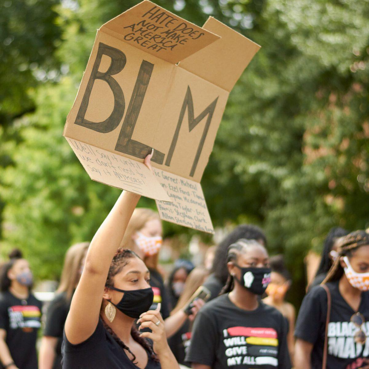A supporter raises a BLM sign during the BLM March on August 29, 2020.