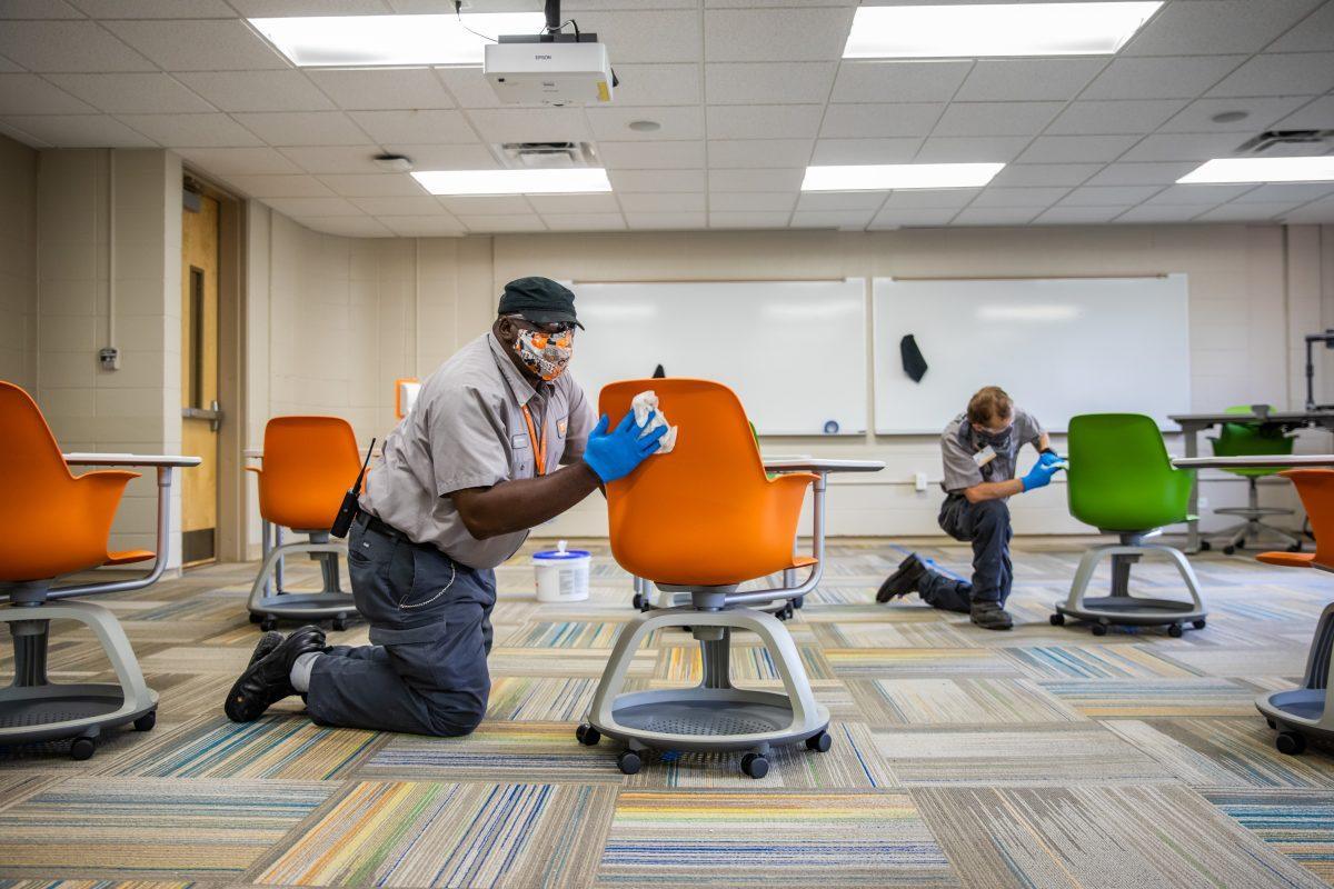 Facilities Services disinfect desks inside a HSS classroom on July 7.