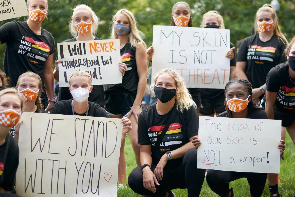 A group of supporters pose with signs at Ayres Hall, at the end of the BLM March on August 29, 2020.
