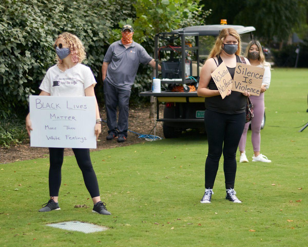 Two students wait while displaying their signs in Circle Park before the BLM March begins, on August 29, 2020.